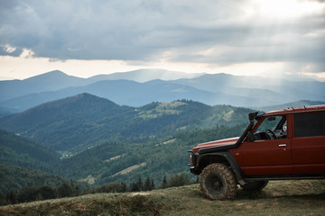 Panoramic view of Carpathian mountains with modern off road car standing on the hills