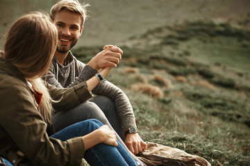 Connected. Positive young bearded hiker smiling and kindly looking at his beloved woman while...