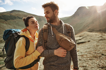 Beautiful couple. Pretty young woman kindly looking at her beloved man while traveling in the...