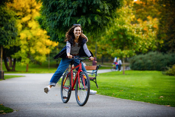 Urban biking - woman riding bike in city park