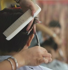 Fototapeta premium hairdresser cutting hair with scissors