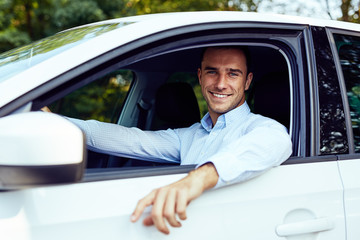 Smiling young man sitting in his car - 226321013
