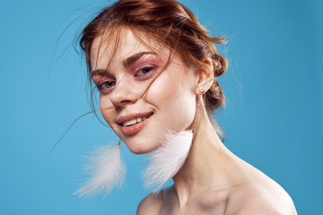 beautiful woman in feather earrings looking at the camera