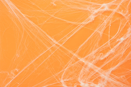 Table top view aerial image of decoration Happy Halloween day background concept.Flat lay accessories essential object to backdrop the white cobweb spider on orange paper.Space for creative design.