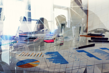 Silhouette of young workers in the office with statistic worksheets. concept of teamwork and business. double exposure