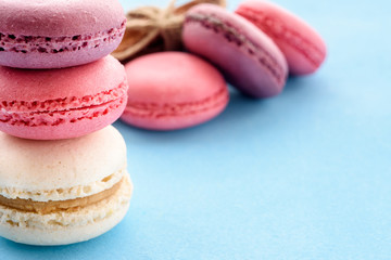 French Macarons on a blue background. Trendy dessert. Sweet cakes.