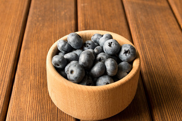 Fresh blueberries on a wooden table in a wooden plate. Close up. The concept of natural food