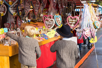 Zwei Jungen, Kinder in Tracht auf dem Oktoberfest in München am Süßigkeiten Stand