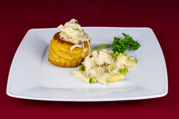 Hühnerfrikassee mit Pastete auf einem Teller serviert mit Spargel und Erbsen garniert mit...