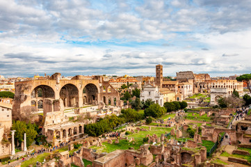 Fototapeta na wymiar Roman forum and Colosseum from the high view in the sunny afternoon with blue sky and small clouds