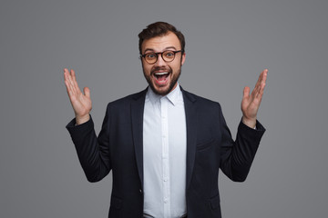 Excited formal man holding hands up