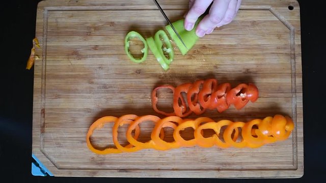 Cut with a knife colored ripe rings of bell pepper lay out patterns and randomly 