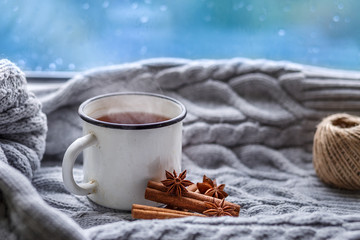The conception of cozy and warmth. A Cup of hot fragrant tea, soft knitted plaid and spices on the...
