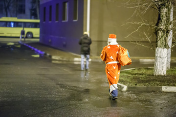 Obraz premium Drunk Santa Claus with a bag of gifts is new year's eve in Russia