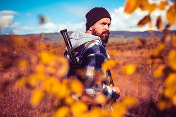 Autumn hunting season. Hunter with shotgun gun on hunt. Autunm hunting. Poacher with Rifle Spotting...