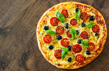 Pizza Margherita or Margarita with Mozzarella cheese, tomato, olive. Italian pizza on wooden background