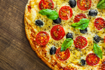 Pizza Margherita or Margarita with Mozzarella cheese, tomato, olive. Italian pizza on wooden background