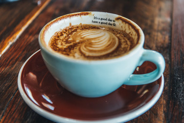 cup of coffee with cream on wooden background