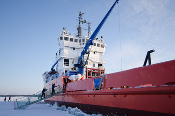 The Icebreaker ship trapped in ice tries to break and leave the bay between the glaciers