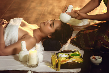 Obraz na płótnie Canvas Close-Up of Woman is Having Relax While Spa Massaging and Skincare Beauty With Thai Herbs, Pretty Woman Lying Down for Thai Massage and Body Herbal Scrub. Healthcare/Beauty Concept