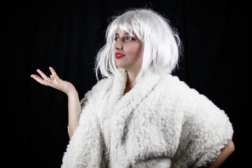 Attractive young woman in costume looking at camera while standing on black background