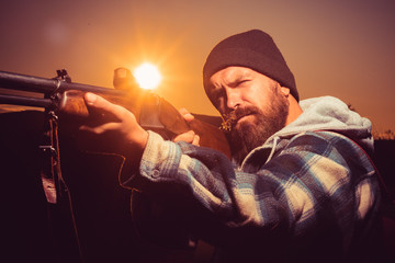 Vintage hunter. Closed and open hunting season. Rifle Hunter Silhouetted in Beautiful Sunset. Calibers of hunting rifles. Hunter aiming rifle in forest.
