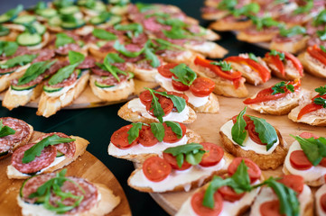 meat and vegetable snacks and sandwiches are laid out on the table