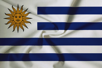 Obraz premium National flag of Uruguay on a waving cotton texture background