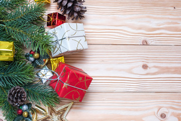 Christmas background with decoration, gift box, Star shape, Bell and pine tree branches on wooden board, Happy New Year and Xmas Holidays banner. Top view and Copy Space for your text