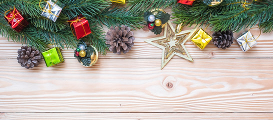 Christmas background with decoration, gift box, Star shape, Bell and pine tree branches on wooden board, Happy New Year and Xmas Holidays banner. Top view and Copy Space for your text