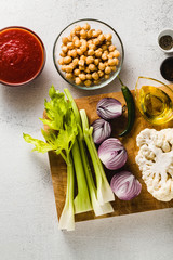 ingredients for cooking soup on a cutting board on a white stone kitchen table.