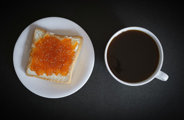 Sandwich with red caviar and coffee. Selective focus.