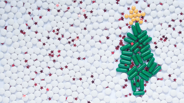 Christmas and Happy New Year theme for healthcare, medical and pharmacy concept. Green christmas tree, white snow and decorative yellow star made by medicine pill/capsule. Creative idea. Copy space.
