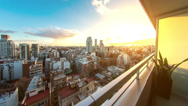 Time-lapse view on the skyline of the city from a balcony of a high rise apartment as Sun breaks through between fast move clouds in Buenos Aires.
