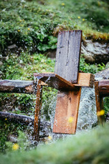 Wasserrad auf Holz auf der Alm, Wassertropfen