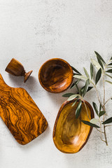 wooden utensils from the olive tree on the white kitchen table and the branches of the olive tree. eco-friendly kitchenware
