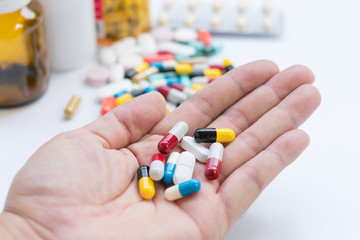 Selective focus Drugs in hand. Senior man holding assorted capsules and pills in his hand. Conceptual of health care for the elderly.