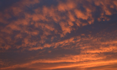 Dramatic sunset sky with orange colored clouds.
