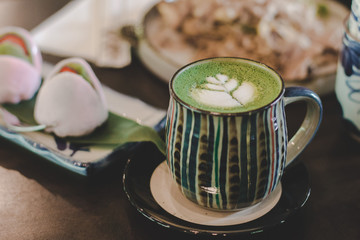 green tea latte with moji on wood background