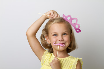 girl holding paper party sticks on a solid background