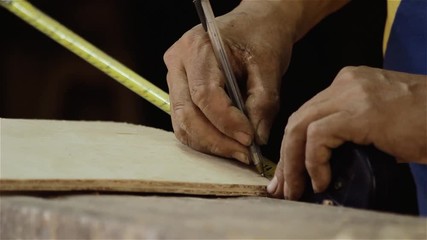 Carpenter Taking Measurements On A Piece Of Wood.