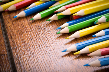 Different colored pencils on the brown wooden table background .Top view .Close up .Color .Pencil.Set