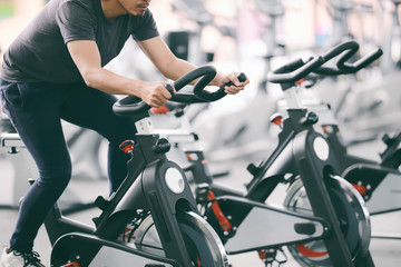 Footage of a man working out in gym on the exercise bike, young man cycling in the gym. man...