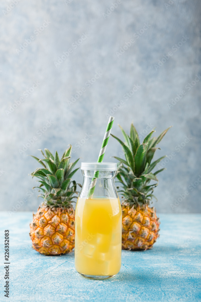 Wall mural fresh pineapple juice and ripe pineapple on grey background