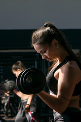 Fototapeta na wymiar young woman lifting weights