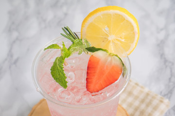 Fruit juice, Strawberry  mixed with soda lemon mint in plastic glass on wooden plate