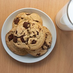Top view of chocolate cookies and a cup of milk on table