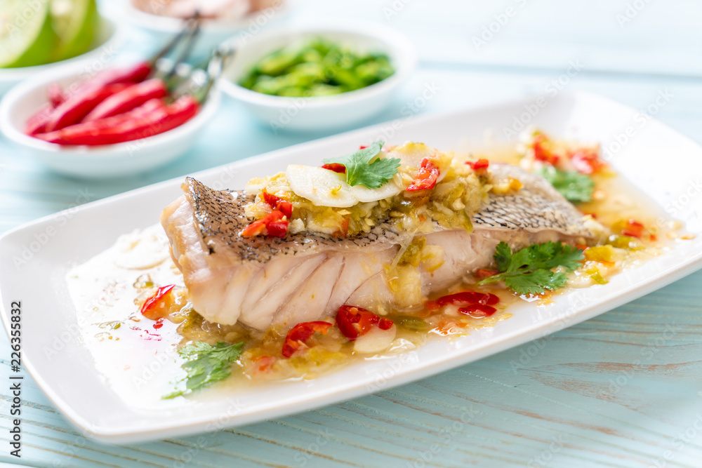 Poster steamed grouper fish fillet with chili lime sauce in lime dressing