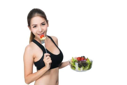 Girl in a fitness suite holds a salad bowl.