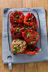 Fototapeta na wymiar ready baked stuffed peppers in a glass baking dish on the wooden table. healthy vegan cuisine for the whole family. comfort food